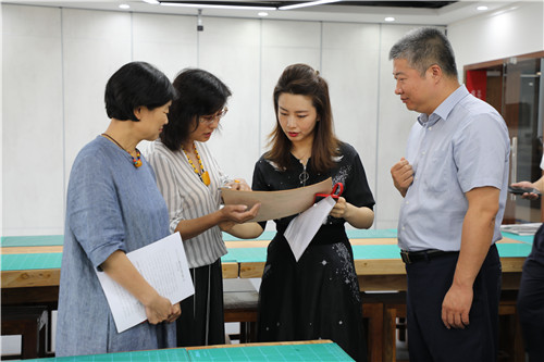 12孙坤琚老师向与会领导介绍皮雕作品